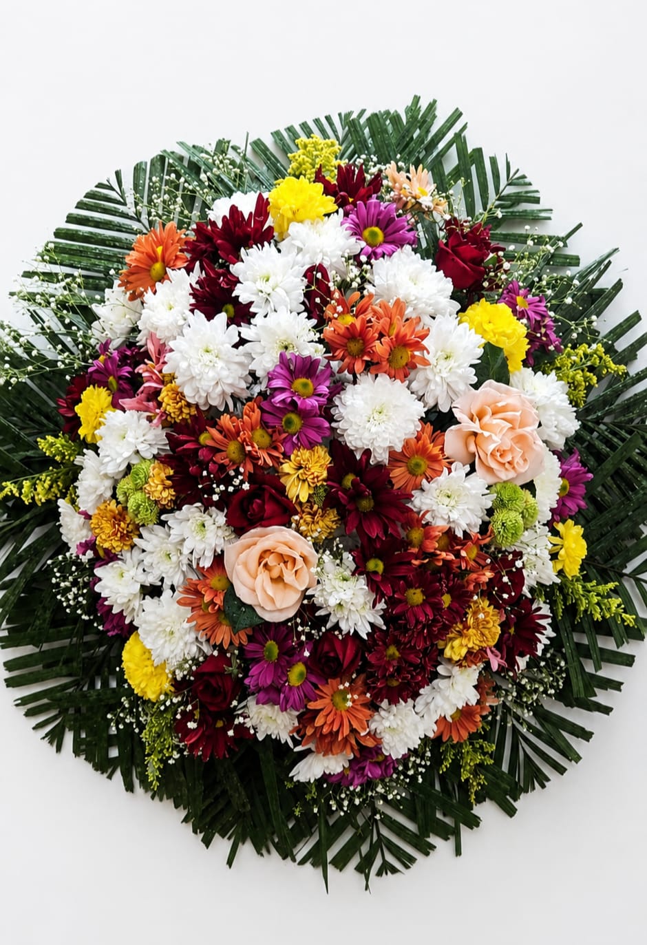 Coroa de flores coloridas com margaridas e rosas